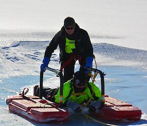 Two men on a raft getting pulled into shore