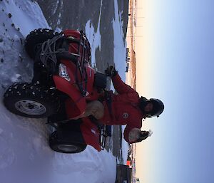 Man on a quad bike holding up a small plastic bag