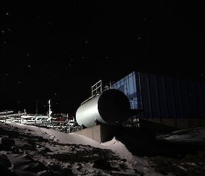 A fuel tank surrounded by snow at night