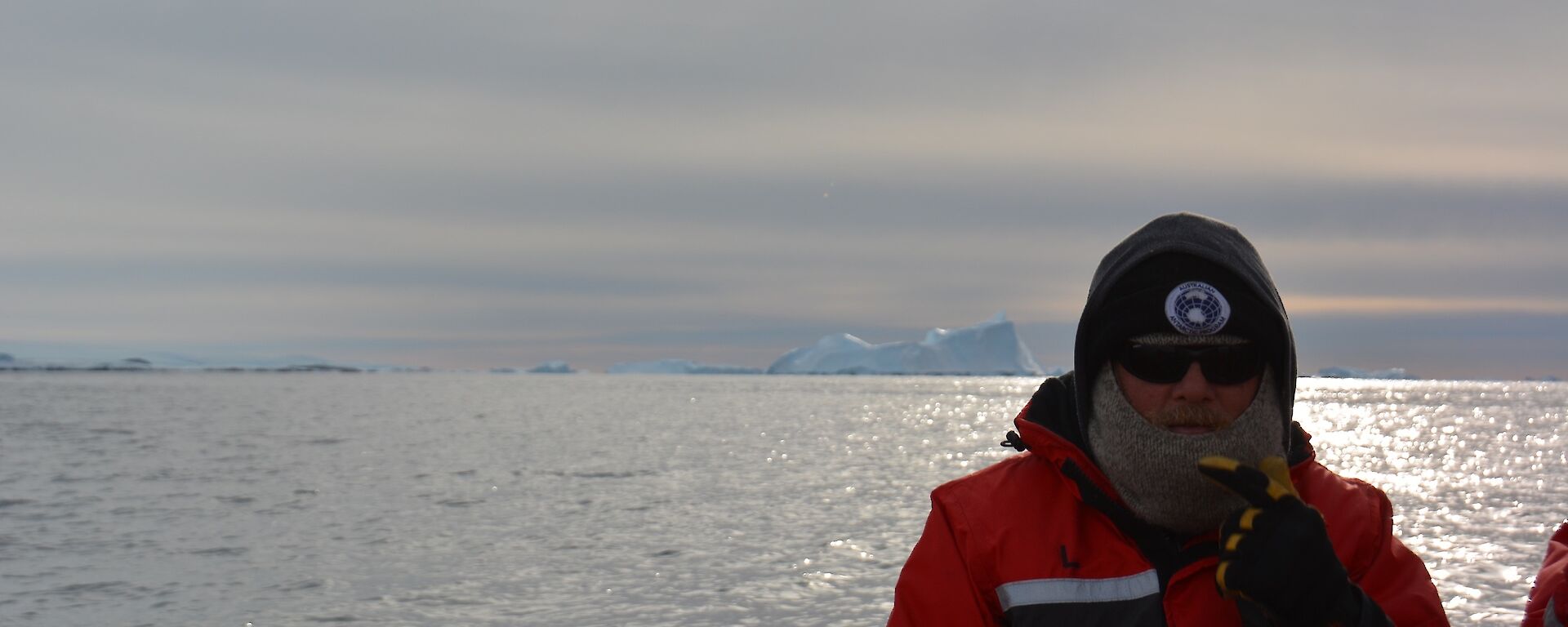 A man sitting in front of an iceberg