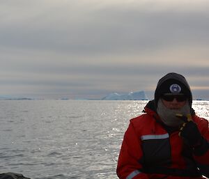 A man sitting in front of an iceberg
