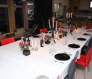 A dinner table set with candle sticks and the good cutlery