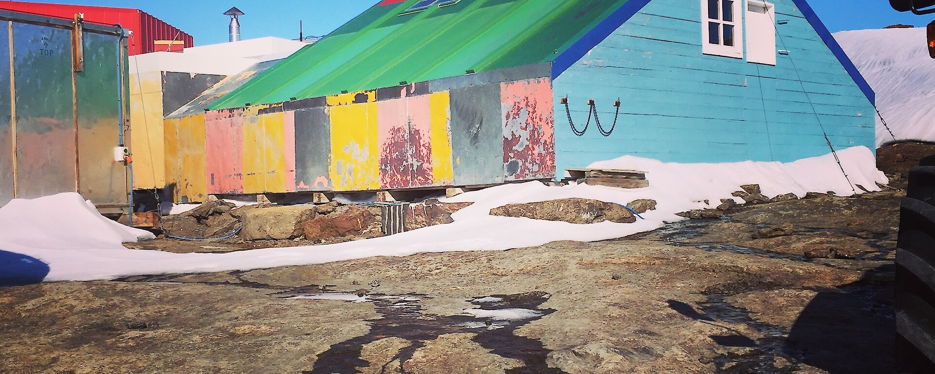 A simple hut made from different coloured pieces of board