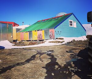 A simple hut made from different coloured pieces of board