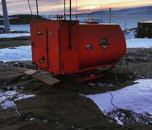 a round orange hut mounted on skids