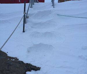 a number of steps cut into snow over a bridge