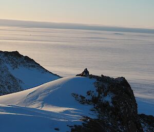 A man sitting on top of a Mountain looking over the Plateau