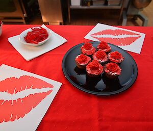 a plate of red cupcakes and red snakes