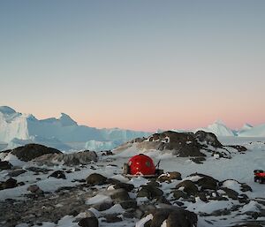 a little hut on an Island surrounded by icebergs