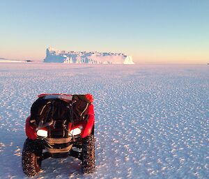 A quad bike in front of an ice berg on the sea ice