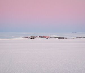 a long stretch of sea ice with the station in the distance