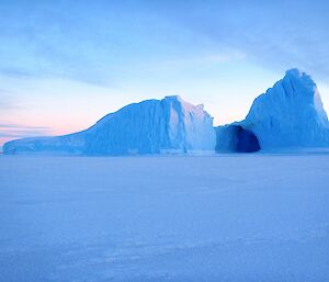 an iceberg with a cave in the side