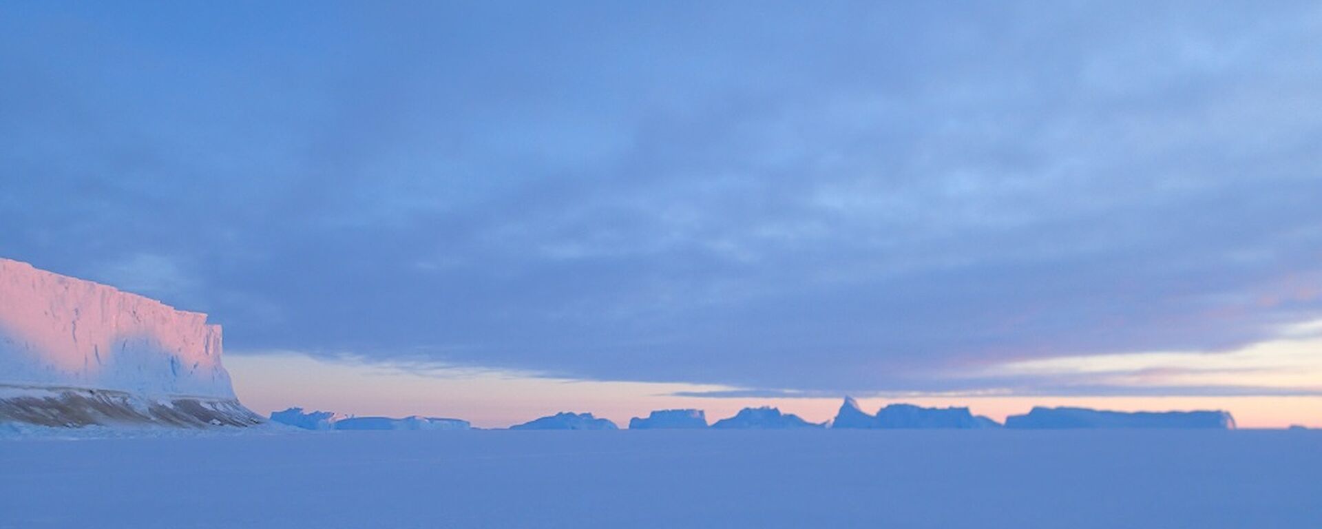 A ice berg with a sunset reflected off it