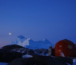 a moonrising over an iceberg