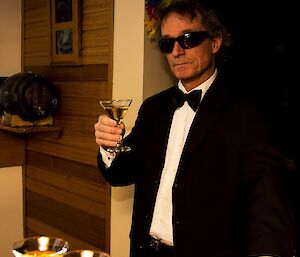 A man in a tuxedo with a martini