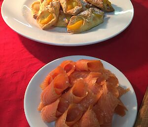 a plate of smoked salmon and danish pastries
