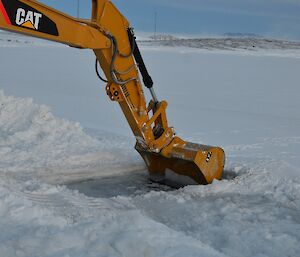 an excavator clearing thin ice out of a pool