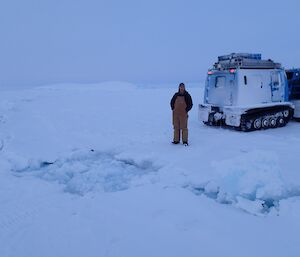 A large tide crack with a hagglund parked next to it