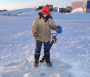 A man fishing through a small hole in the ice