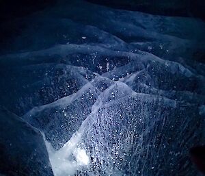 a frozen lake with light shining through the ice
