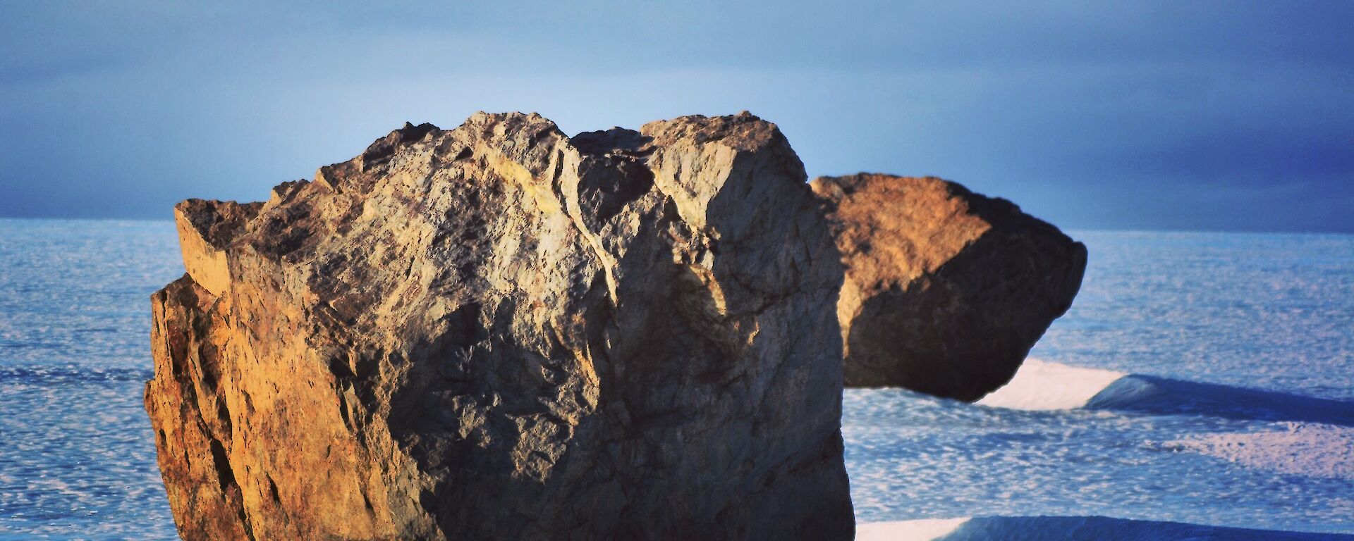 two large rocks in a line on a glacier