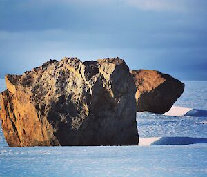 two large rocks in a line on a glacier