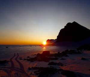 a sunrise near some mountains