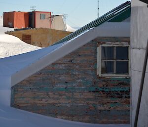 a wooden building that is buried in snow with a pane glass window