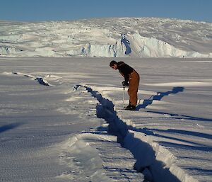 A man standing on the edge of a tide crack