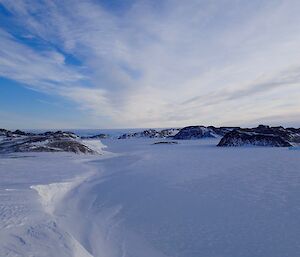 a clear day with high clouds, bright sun and lots of sea ice