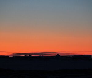 A pink orange sunset over the sea ice