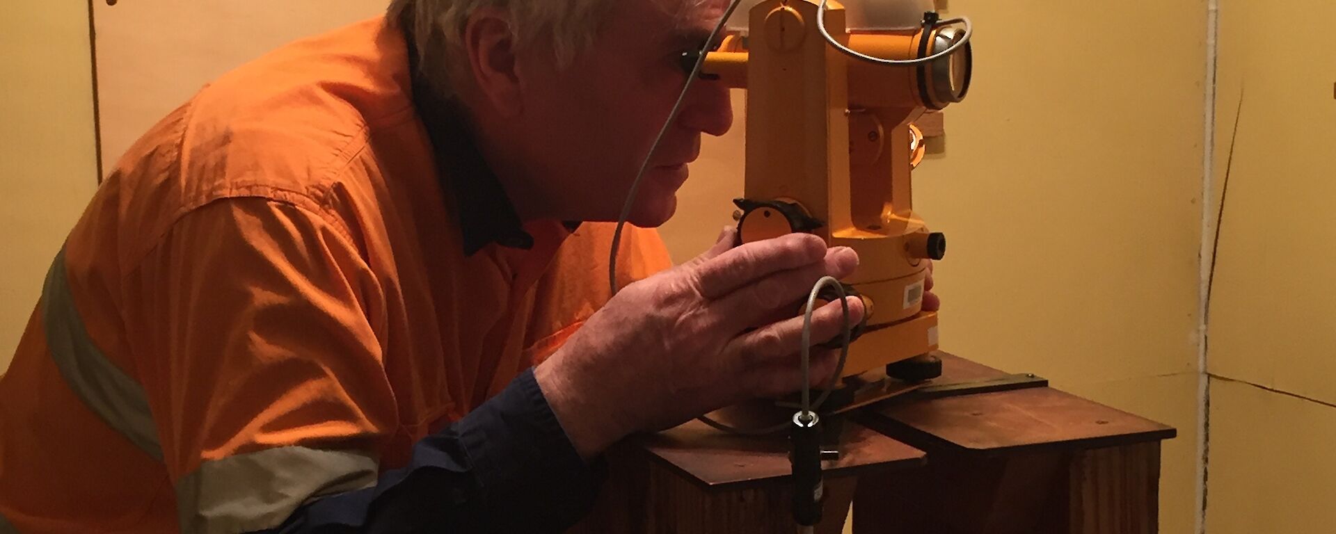 A man looking through a binocular like instrument
