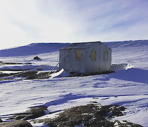 a small wooden hut in front of a glacier