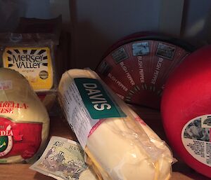 A shelf of cheeses with a five pound note