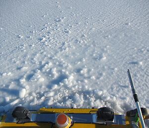 A yellow Hägglunds sinking into the sea ice