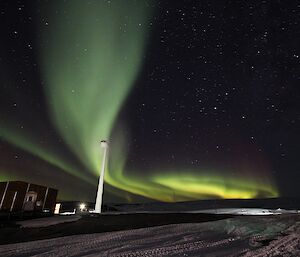 A green aurora over a wind turbine