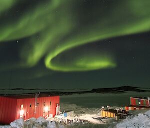 A large green aurora over the top of the station station buildings