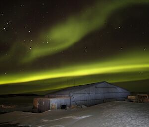 A yellow aurora over the old hanger building