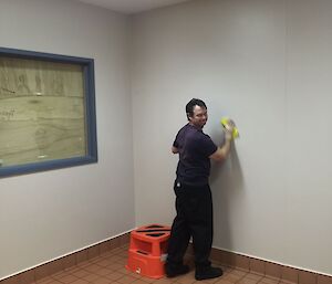 a man washing down the walls in the kitchen