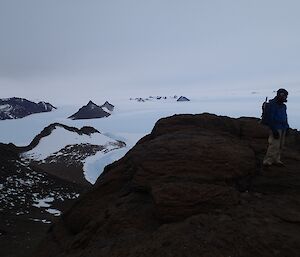 A man with a beard on top of a mountain