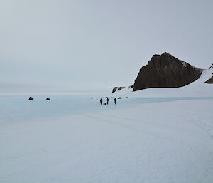 three expeditioners walking off into the distance