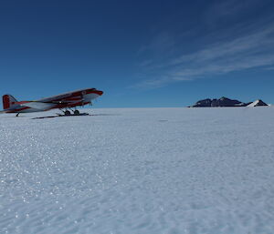 A plane taxiing to the apron area with the North Masson Range in the background