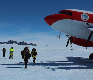 The seven departing expeditioners walking to the plane