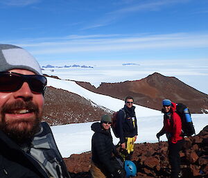 Three expeditioners in the Central Masson Range taking pictures of themselves.