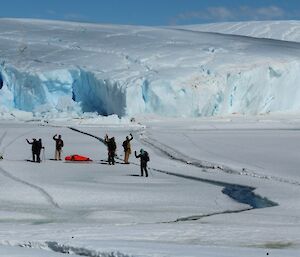Expeditioners wave farewell before crossing the first of many tide cracks in the fast ice