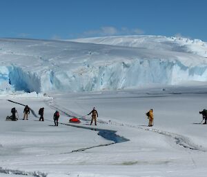 The sleds are taken carefully across the opening tide crack at the narrowest part