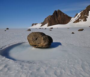 A view of rocks and ice with clear sunny skies.