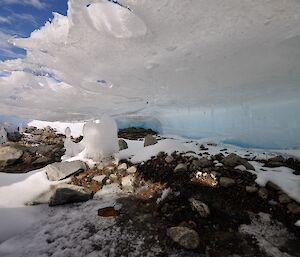 A phot of Patterned Lake with a frozen wave formation and tunnel through the ice and moraine debris