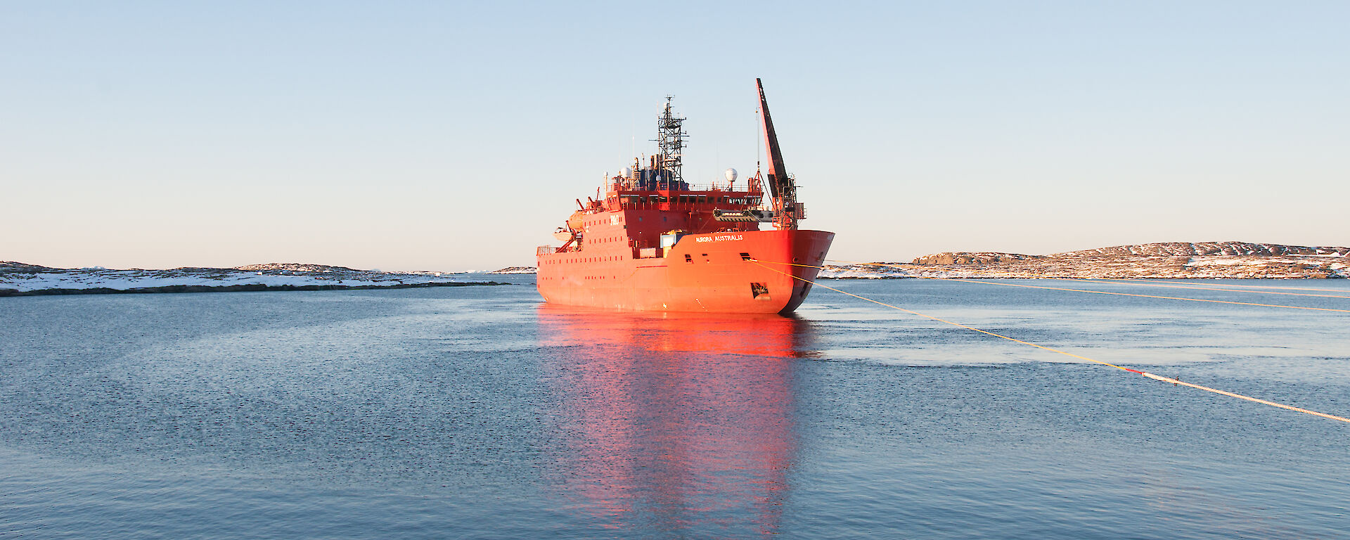 The Aurora Australis in the harbour at Mawson in calm waters.