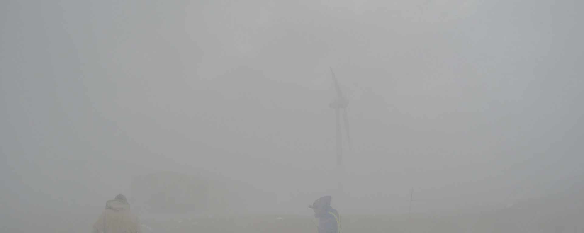 Two expeditioners heading down to the main power house at Mawson during a blizzard